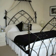 Bed with matching black cushions and bed valance