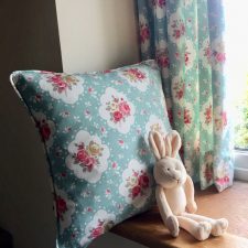 Pink and blue patterned curtains and cushions