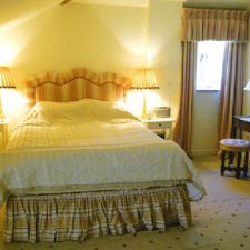Cream and orange head board with complimentary bedding and curtains