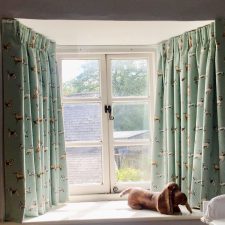 Green dog patterned curtains on track