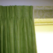 Green curtains with patterned lighter green roman blinds