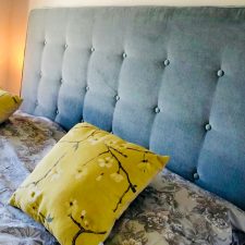 Floral yellow cushion with plain blue headboard